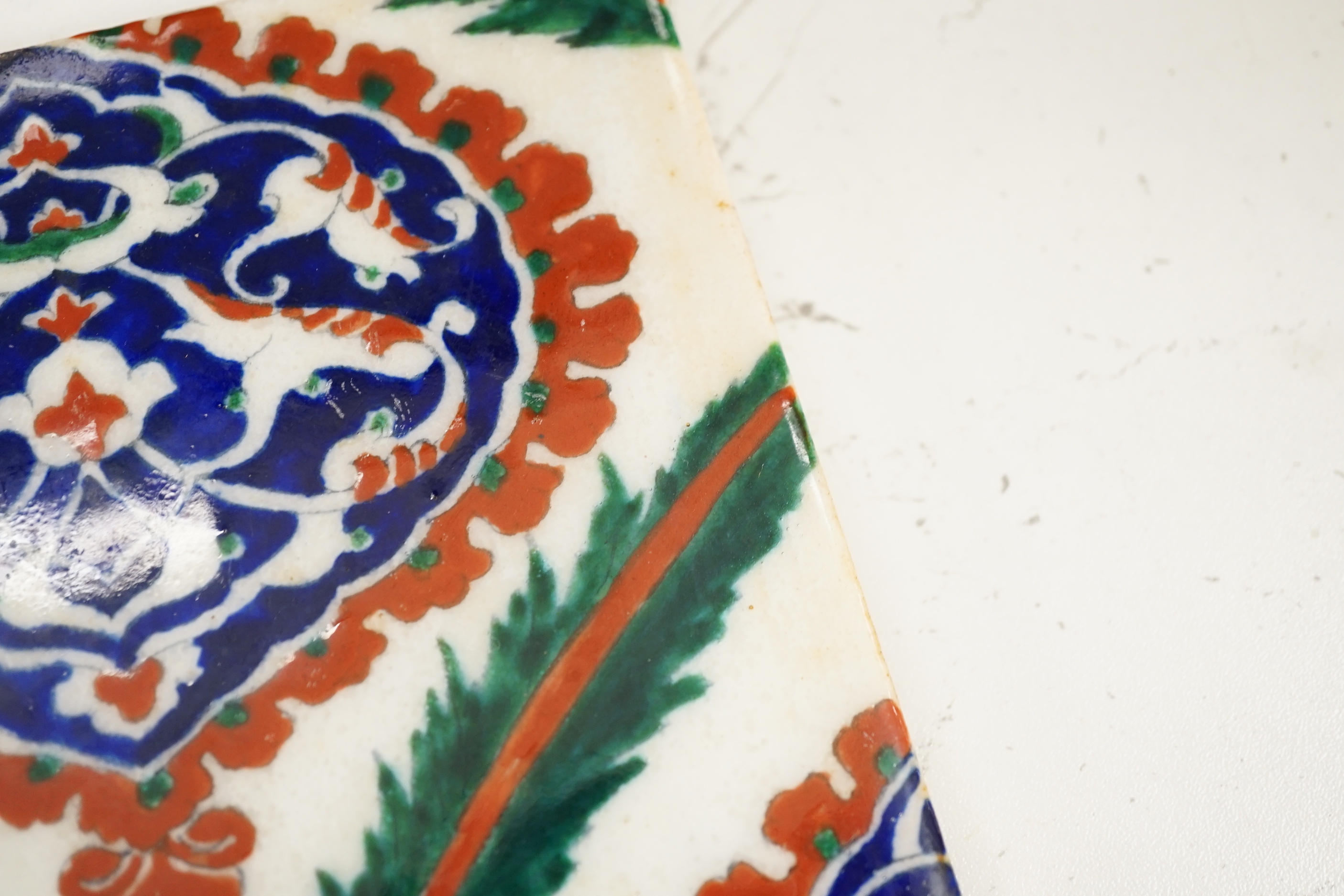 A large Turkish Iznik pottery tile, decorated with stylised flowers, 34cm x 25cm